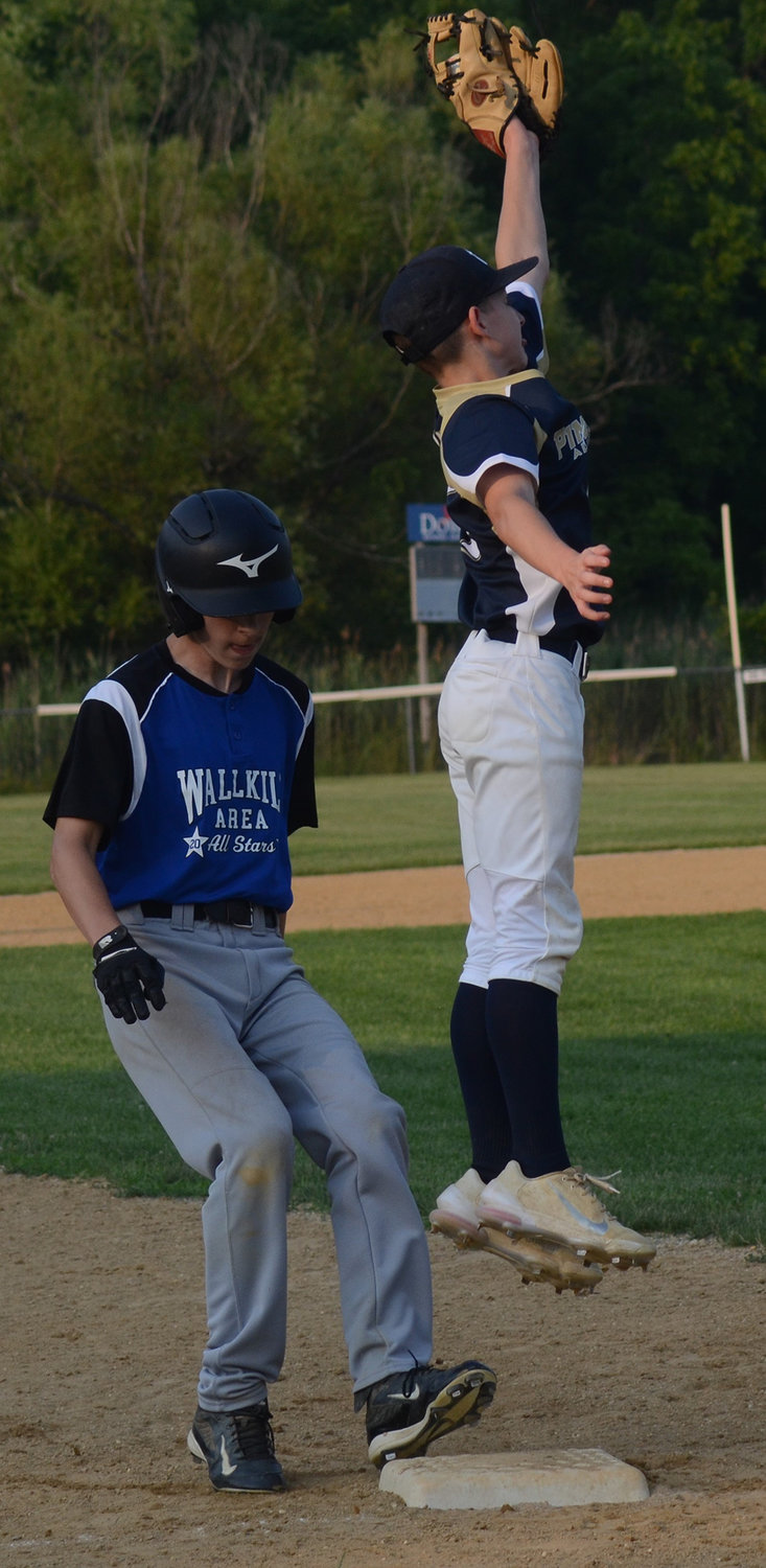 Wallkill Area’s Nik Mandich pulled into third base as Pine Bush third baseman Zach Graziano jumps to take the throw during Wednesday’s District 19 Junior baseball game at Pine Bush Town Park.
